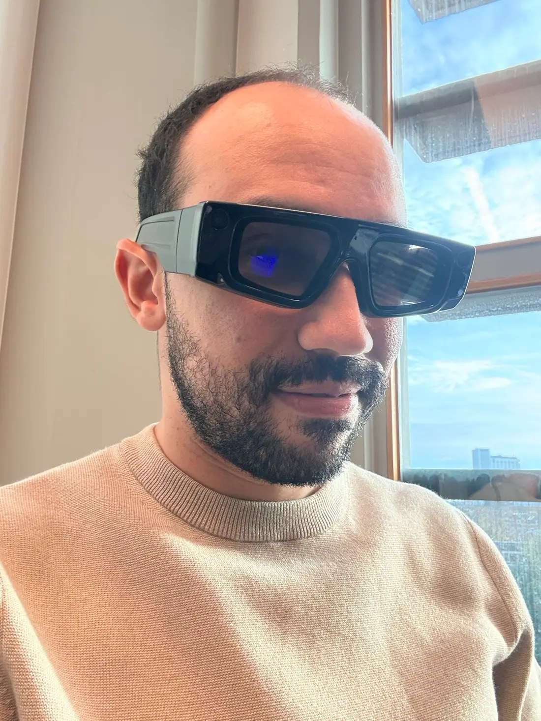 Ely Santos wearing smart glasses by a window